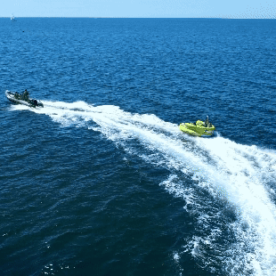 Aerial video of group of people enjoying the Inflatable Sofa ride on the clear waters of Alvor, showcasing thrilling water fun.