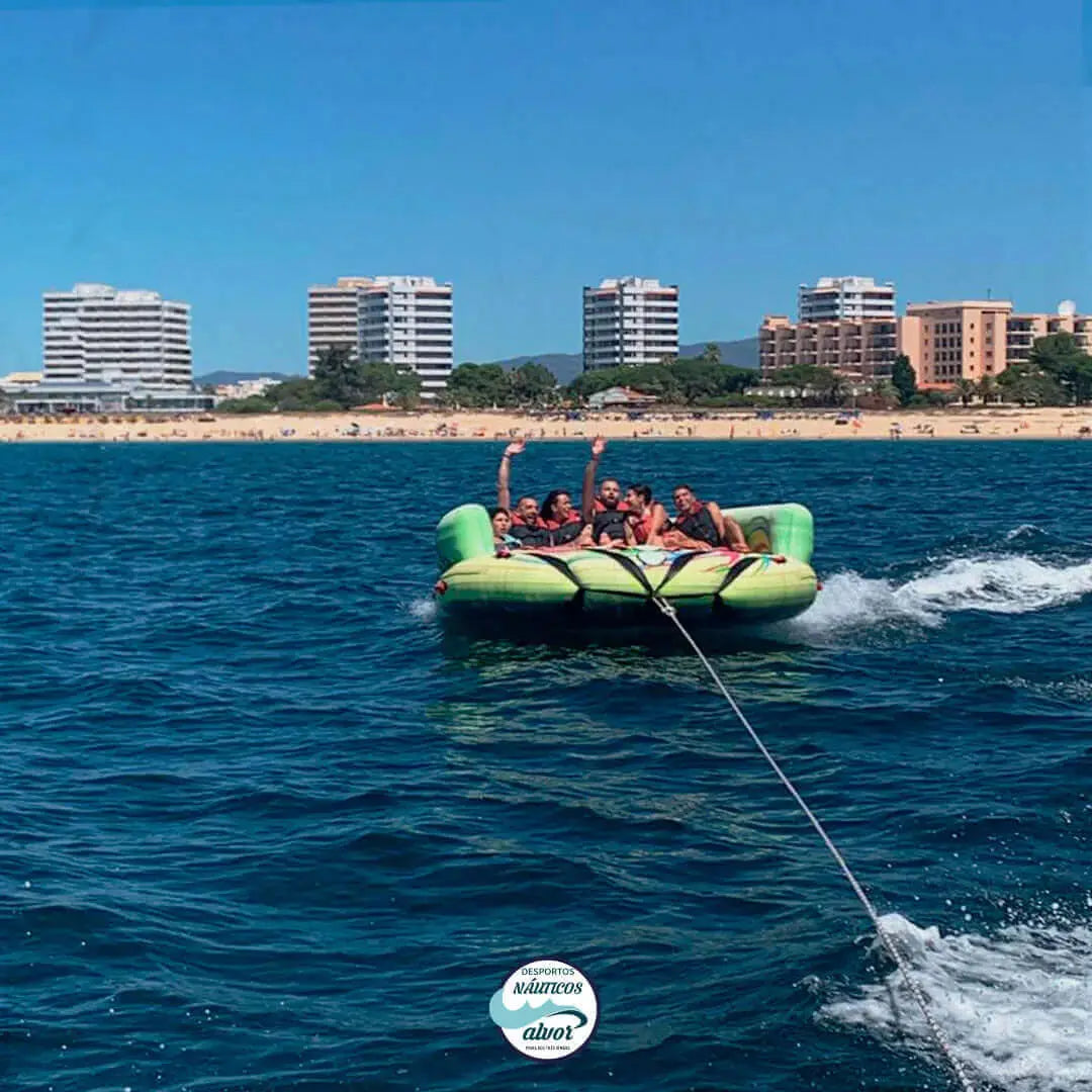 group of people enjoying the Inflatable Sofa ride on the clear waters of Alvor, showcasing thrilling water fun.