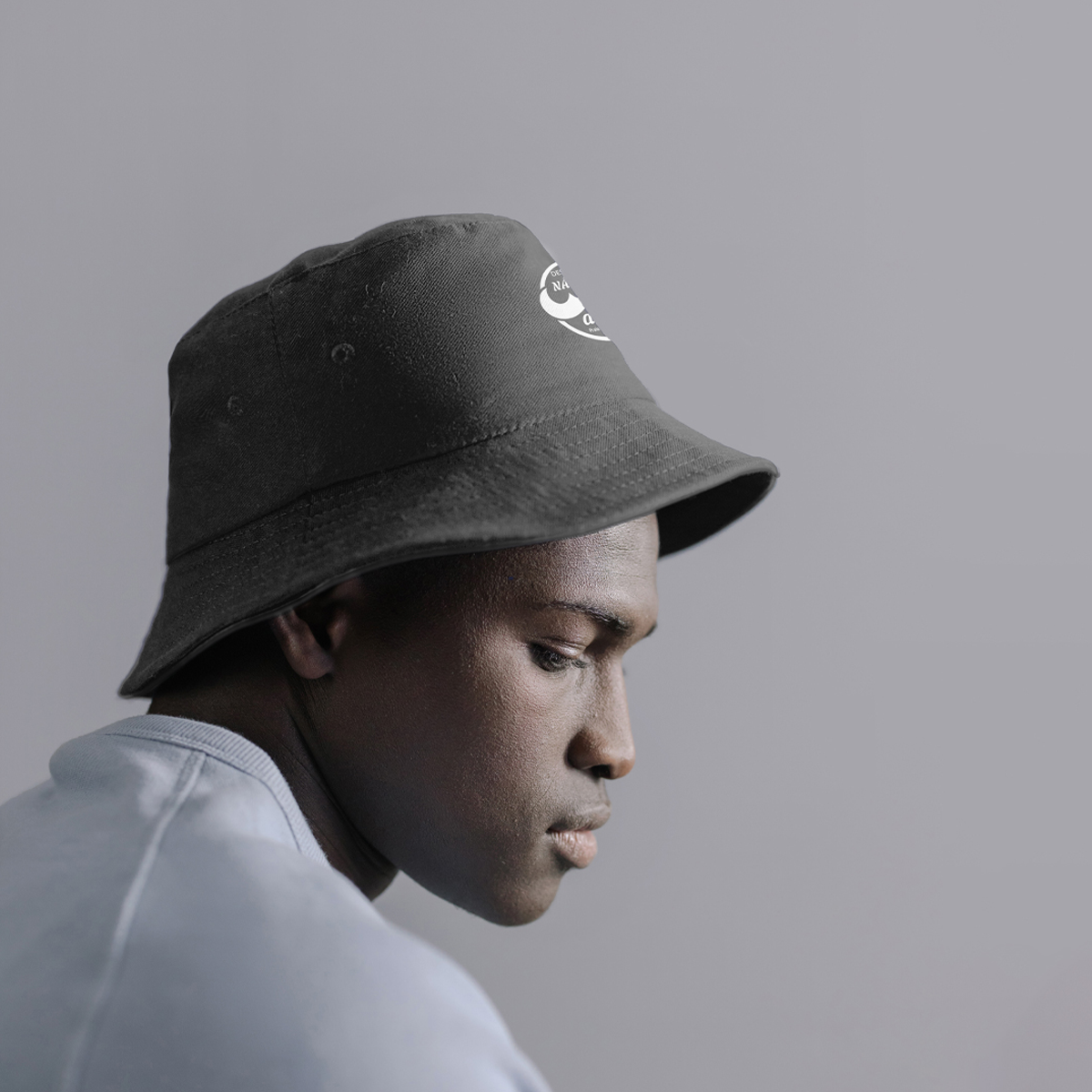 Person wearing a Bucket Hat - Coastal Edition, showcasing its stylish design and comfortable fit in a side profile view.